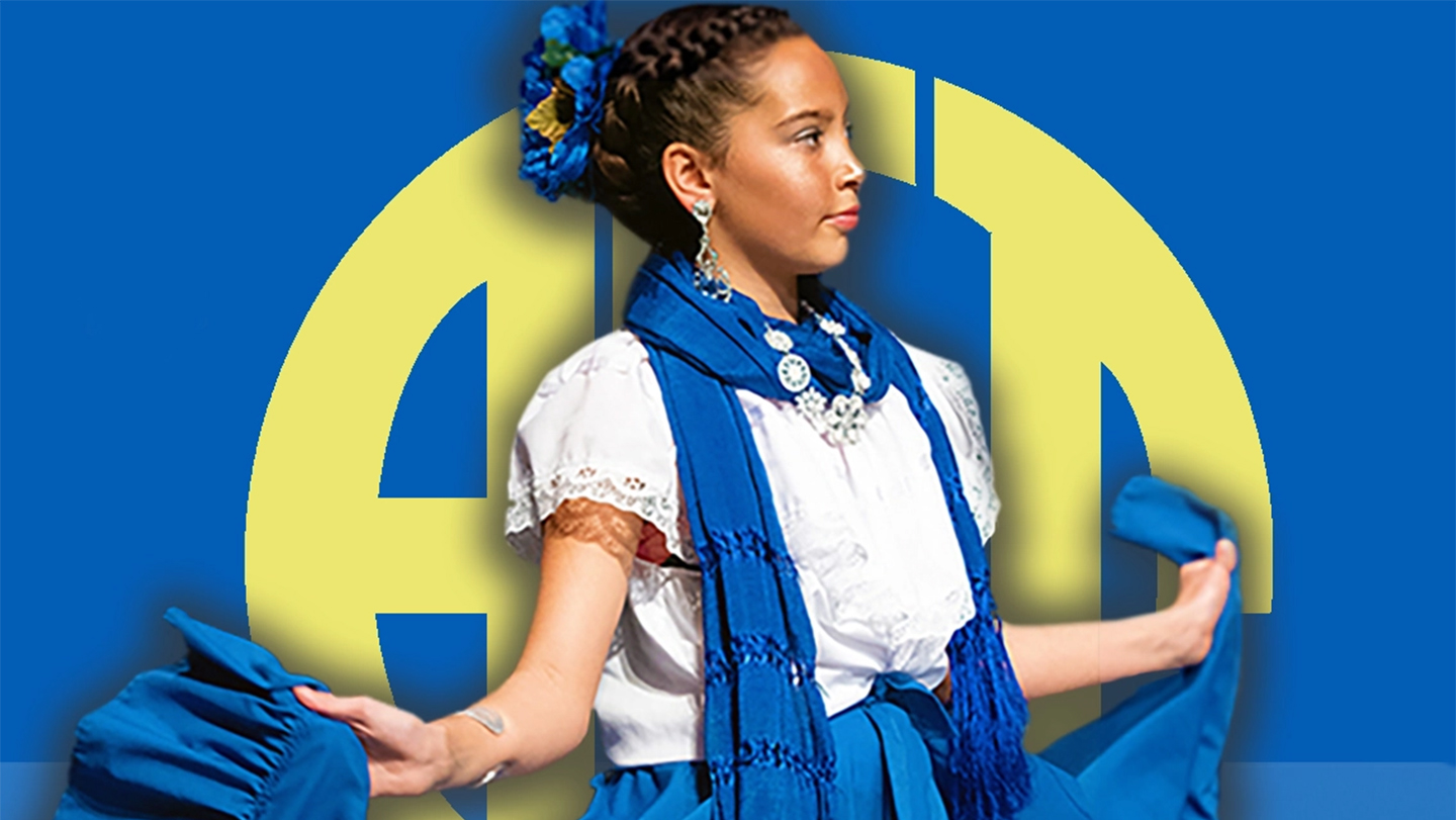 A young performer wearing a traditional Mexican dress on stage with a logo for the Annual Community Telethon as a backdrop